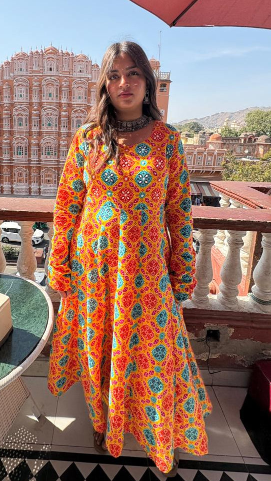 Woman in a colorful dress standing on a balcony with a cityscape in the background